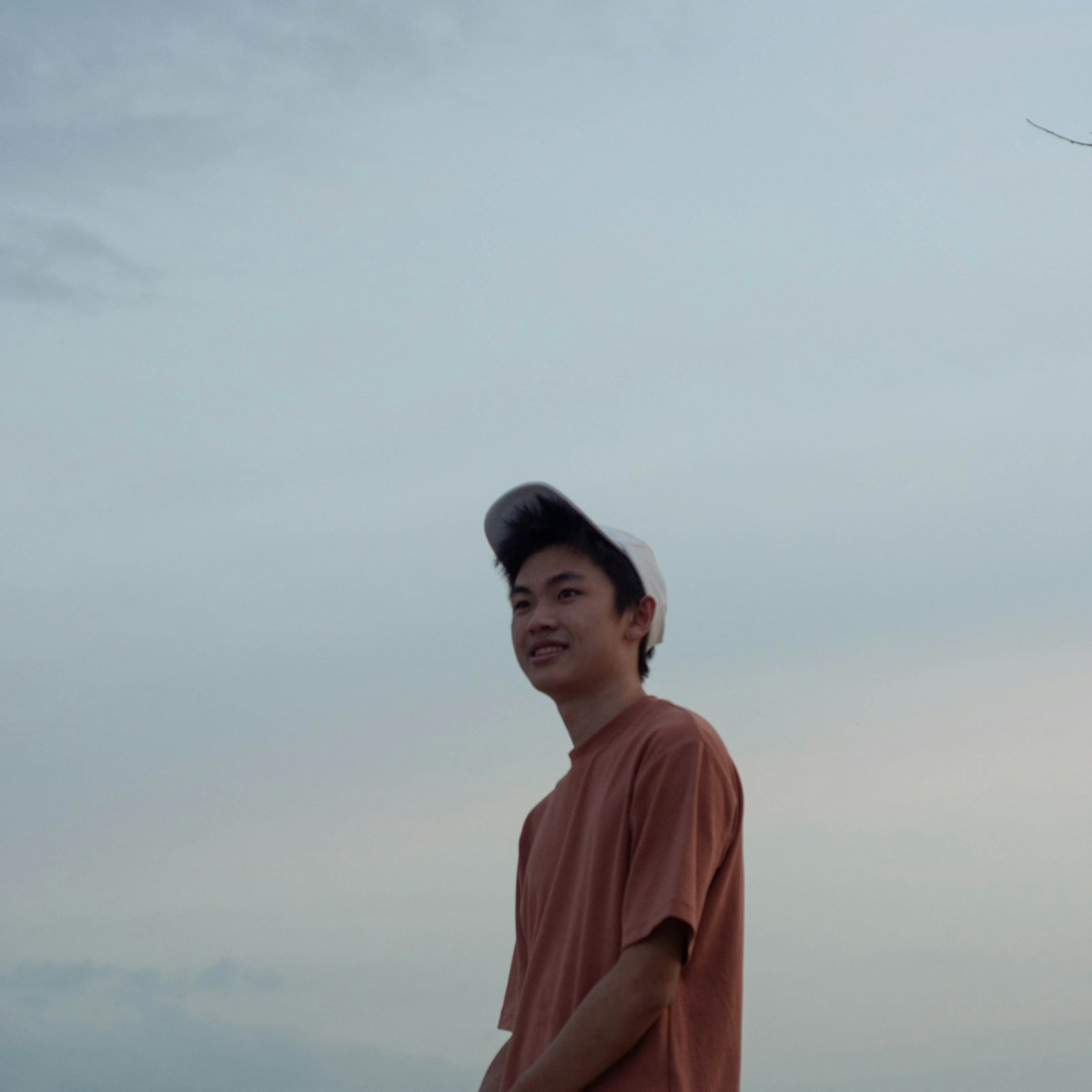 a man standing on a beach with a kite flying in the sky