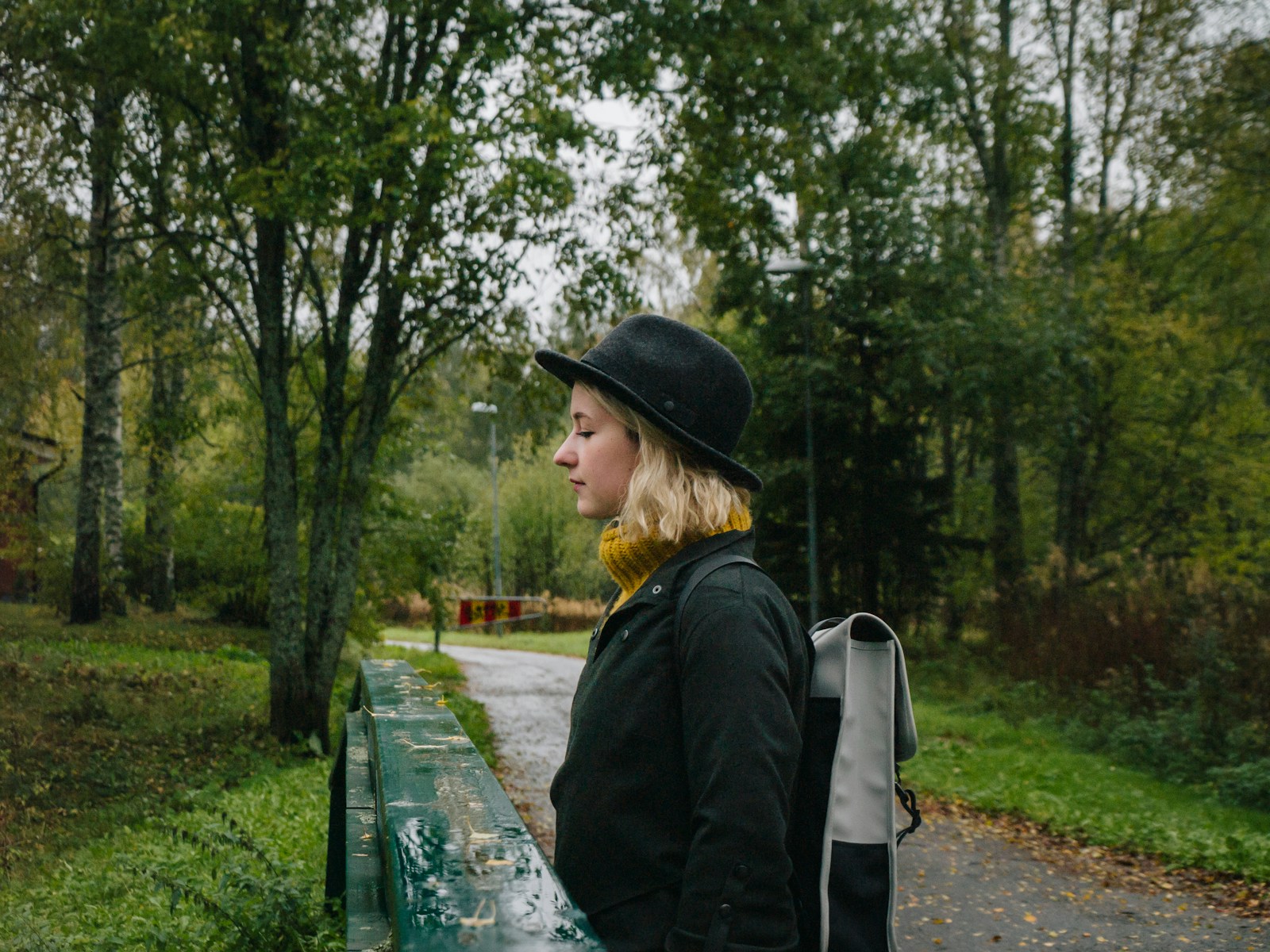 a woman with a backpack is standing on a bench