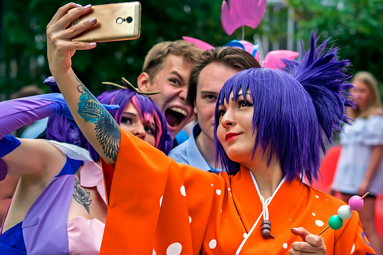 a woman with purple hair taking a picture with her cell phone