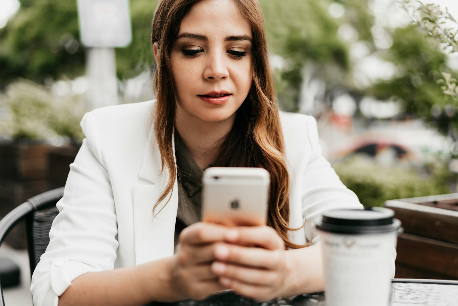 woman in white blazer holding white samsung android smartphone