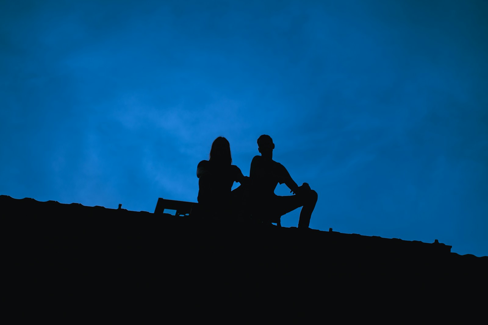 a couple of people sitting on top of a hill