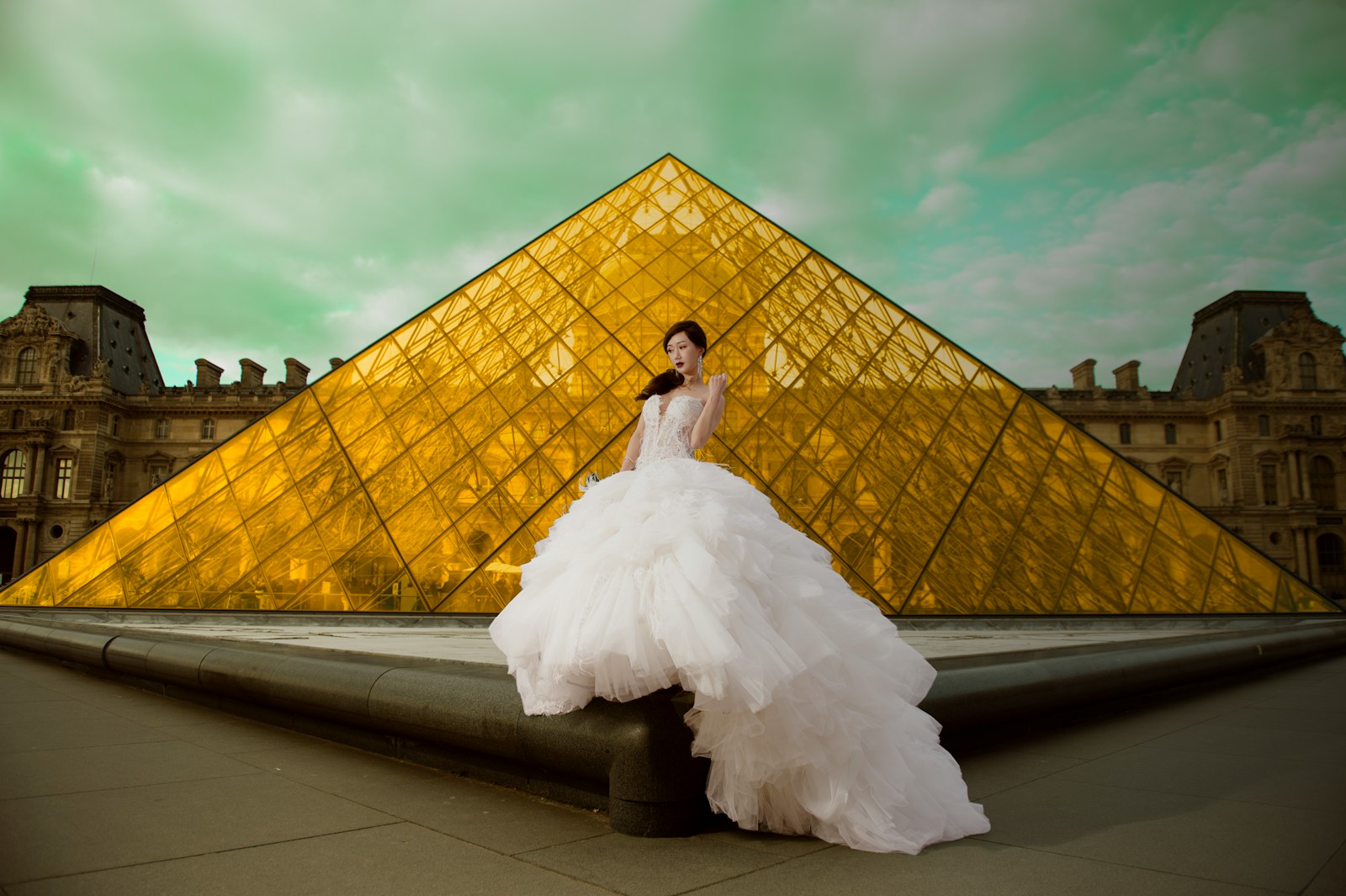 a woman in a white dress standing in front of a pyramid