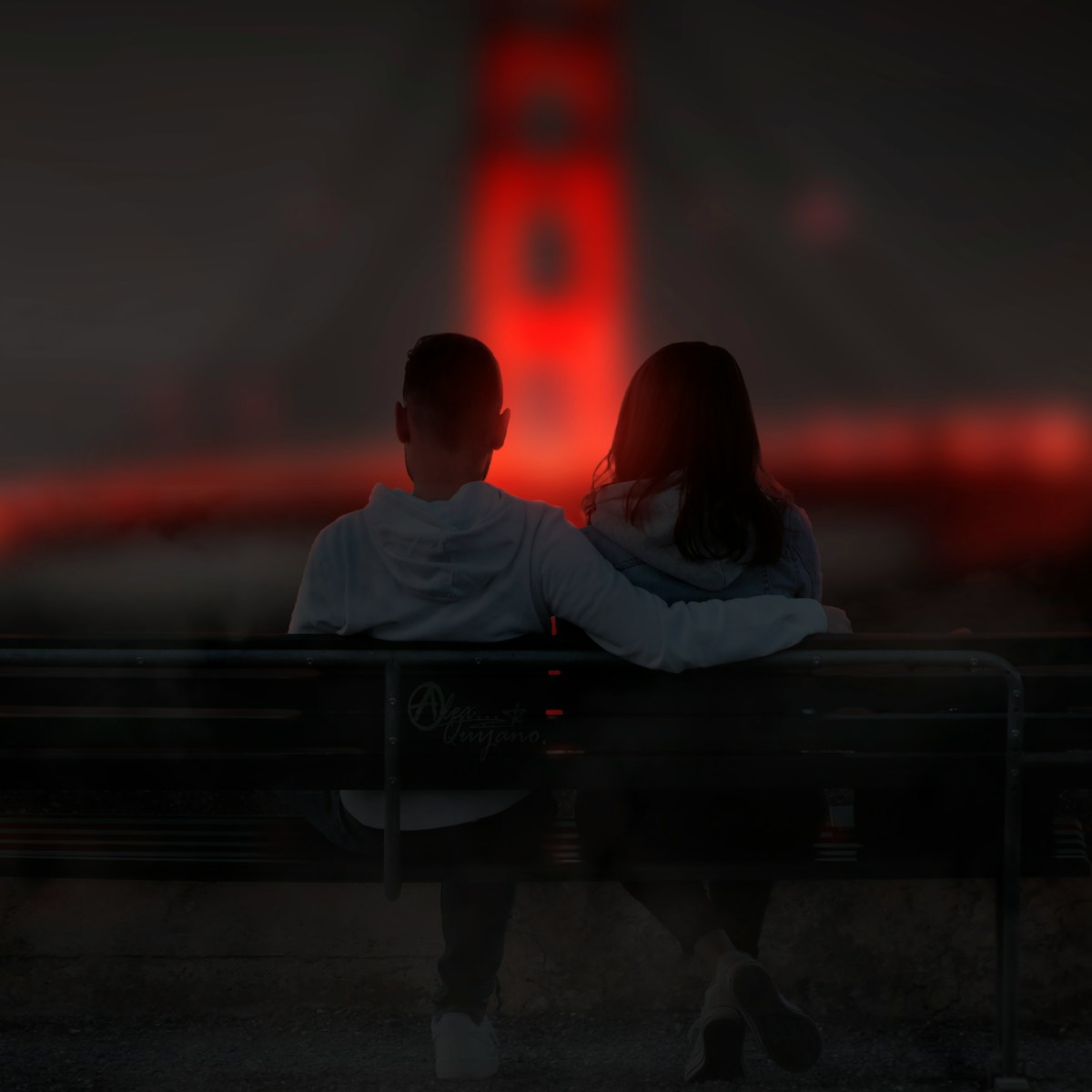 man and woman sitting on bench