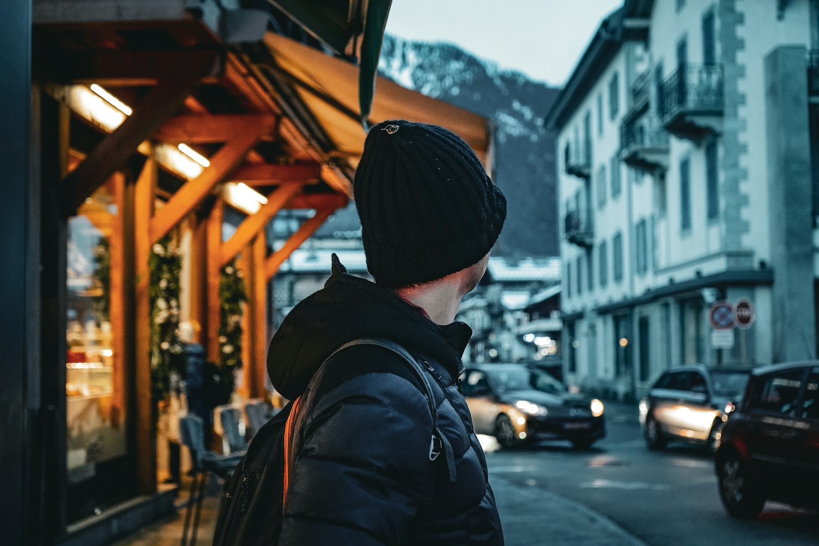 a man standing on a street corner in front of a building