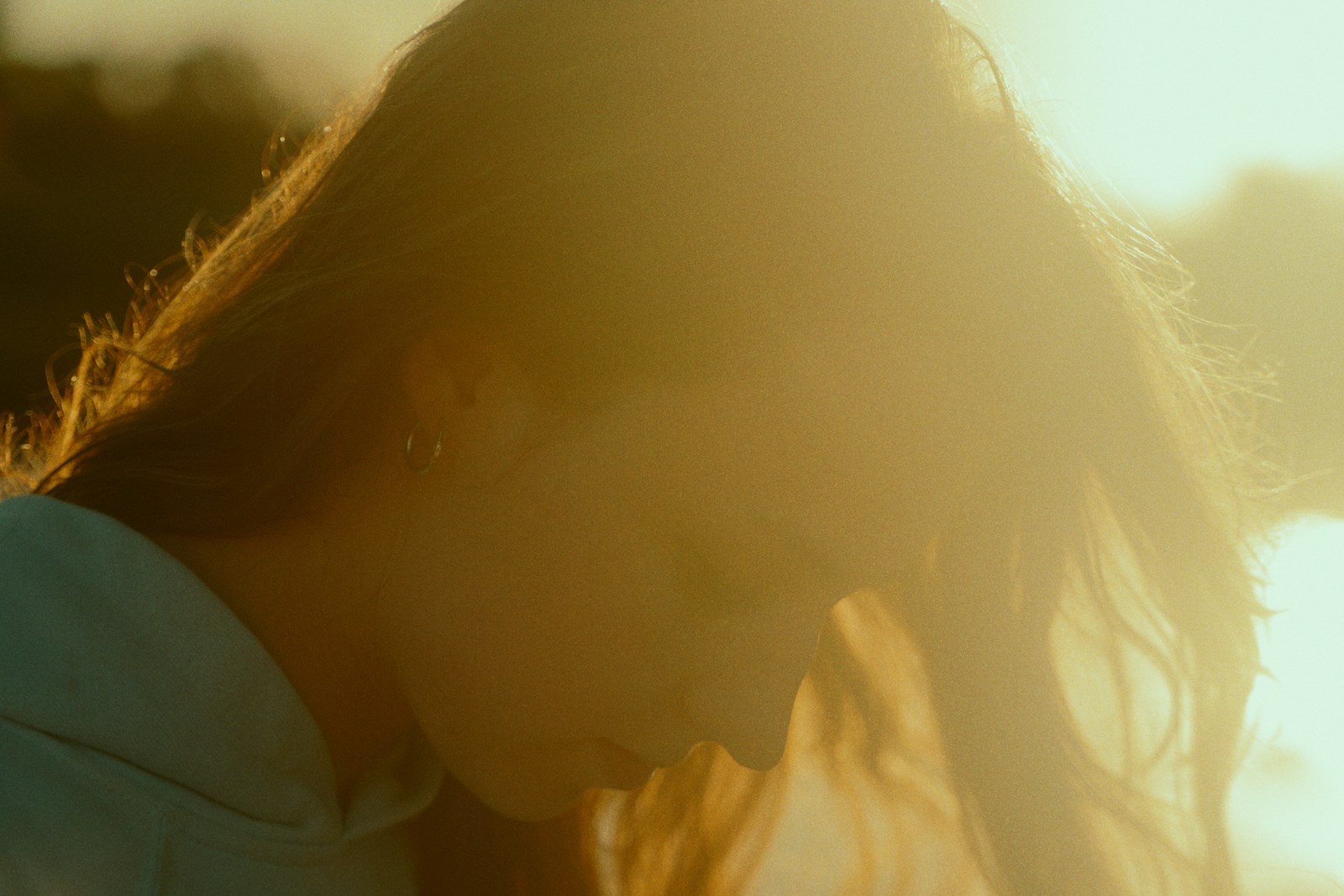 a woman with long hair standing in the sun