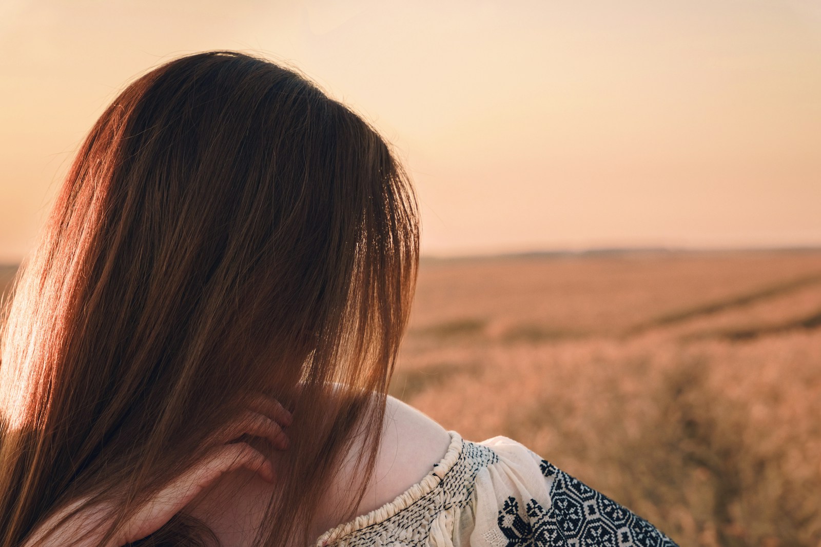 a woman's back with a sunset in the background