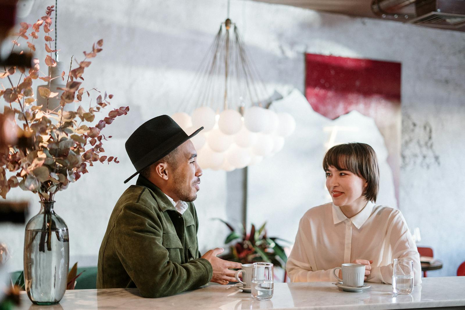 A candid moment capturing a friendly chat in a stylish café setting. Elegant and warm.