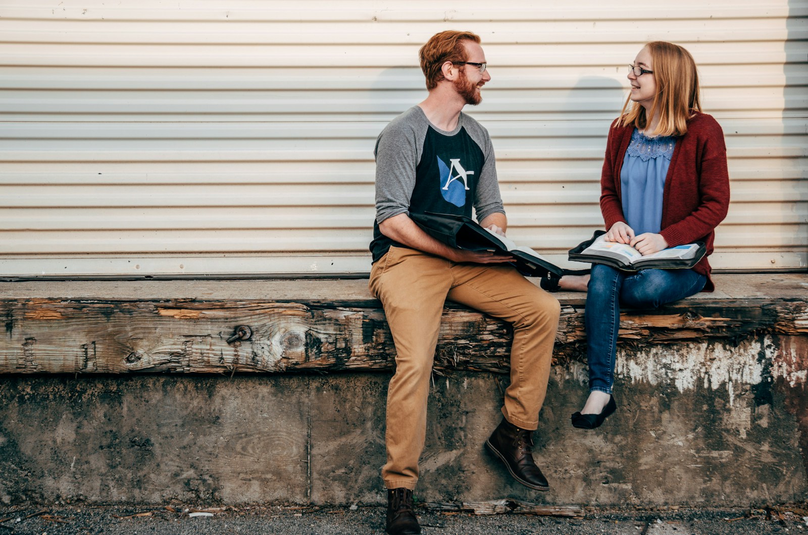 man and woman sitting on wooden bench